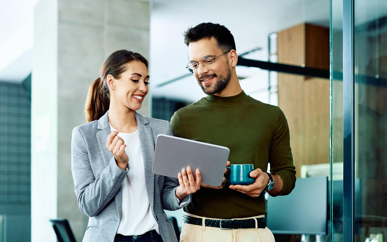 Man and woman in office looking at tablet