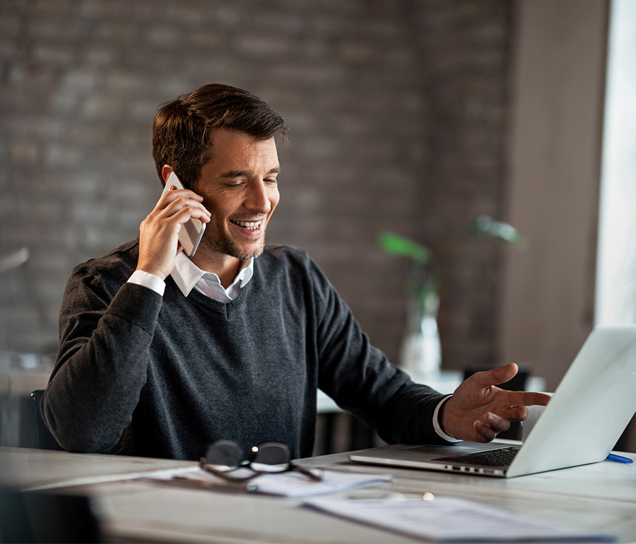 Man talking on phone at laptop