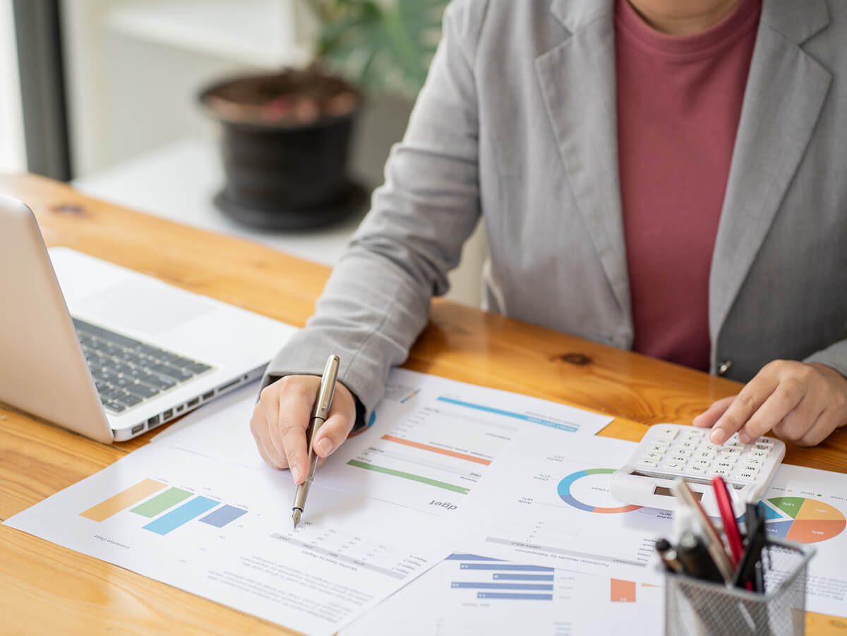 Woman looking at graphs and charts with calculator